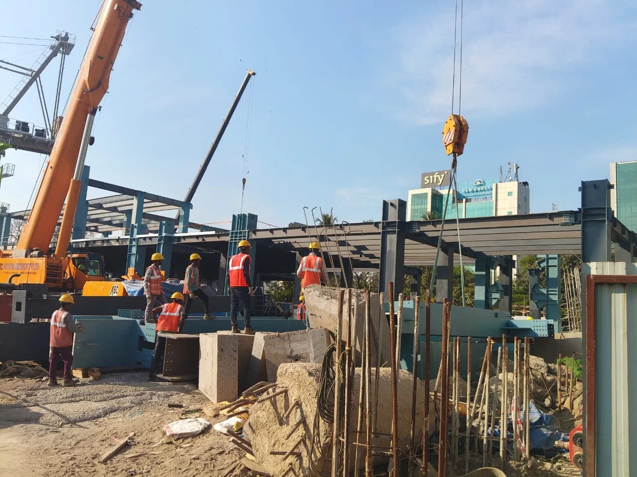 Crews in hard hats and hi-vis setting steelwork at the Lumina site, two cranes working over the frame
