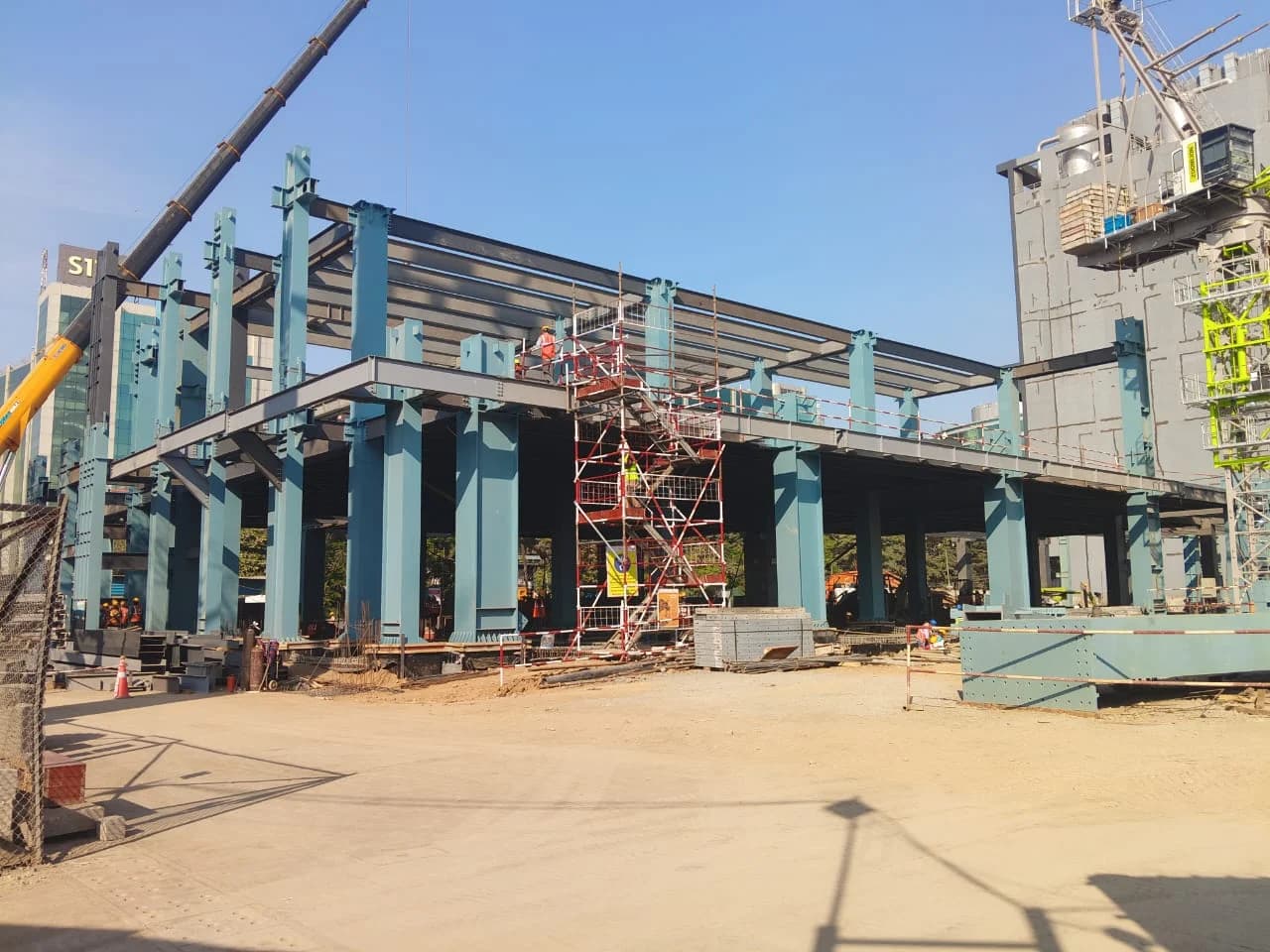 The Lumina data-centre build: a painted steel frame going up over a concrete deck, with scaffold and a crawler crane alongside