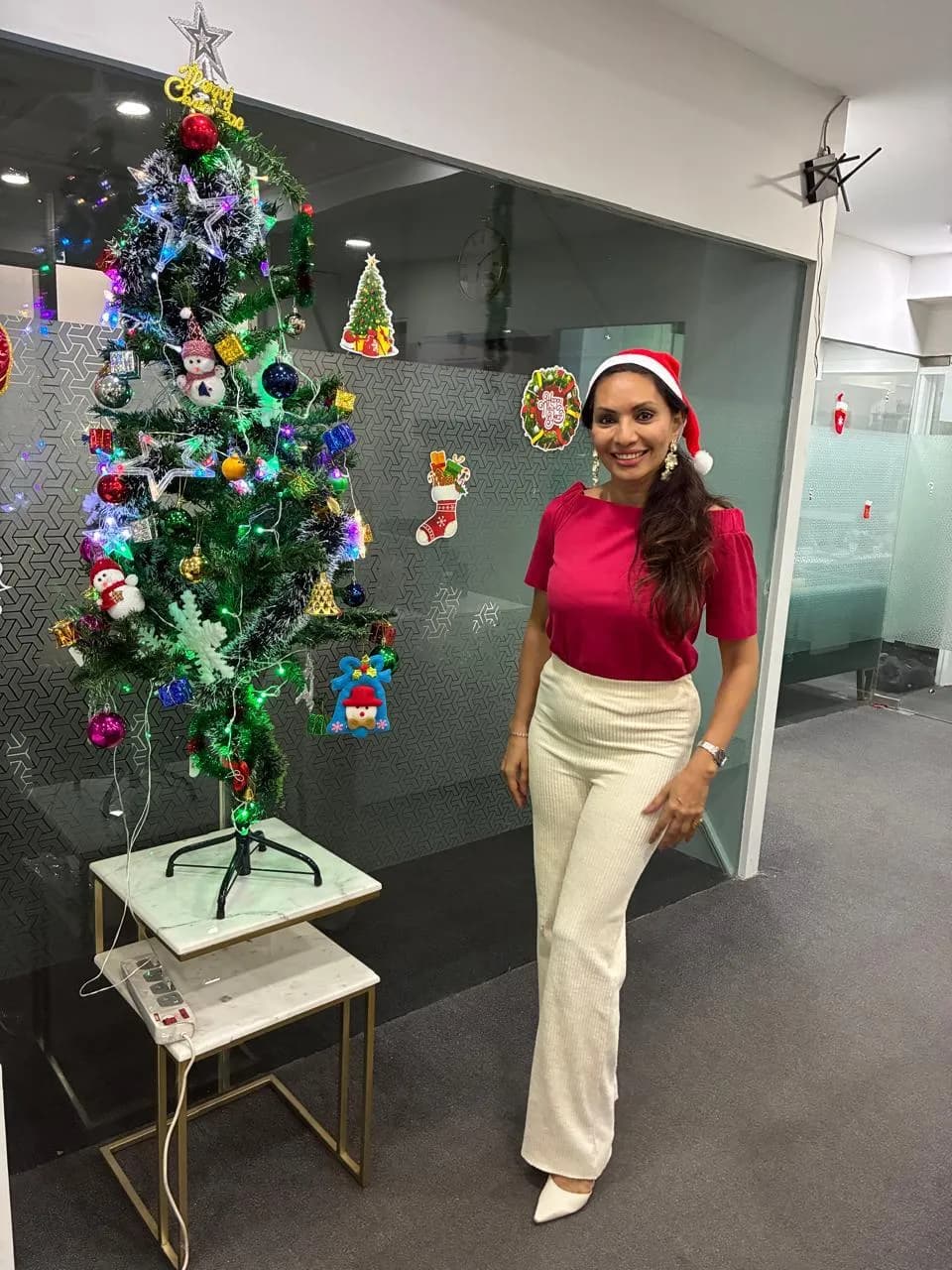 A decorated Christmas tree and KIPL colleagues in Santa hats at the office