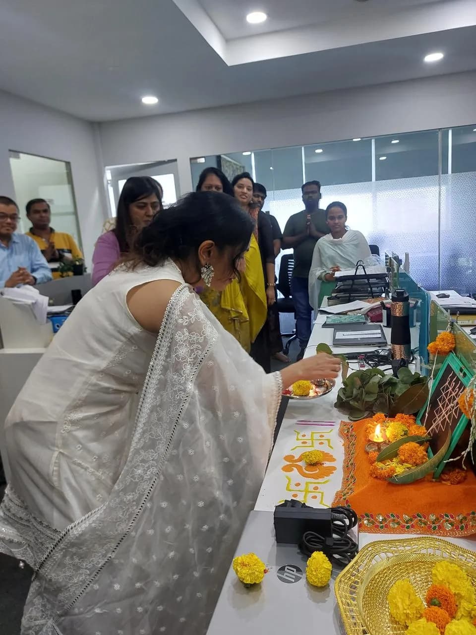 Marigolds and puja offerings laid over office equipment for Dussehra