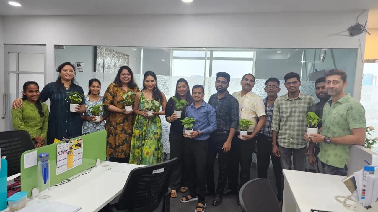 KIPL colleagues holding potted saplings on World Environment Day