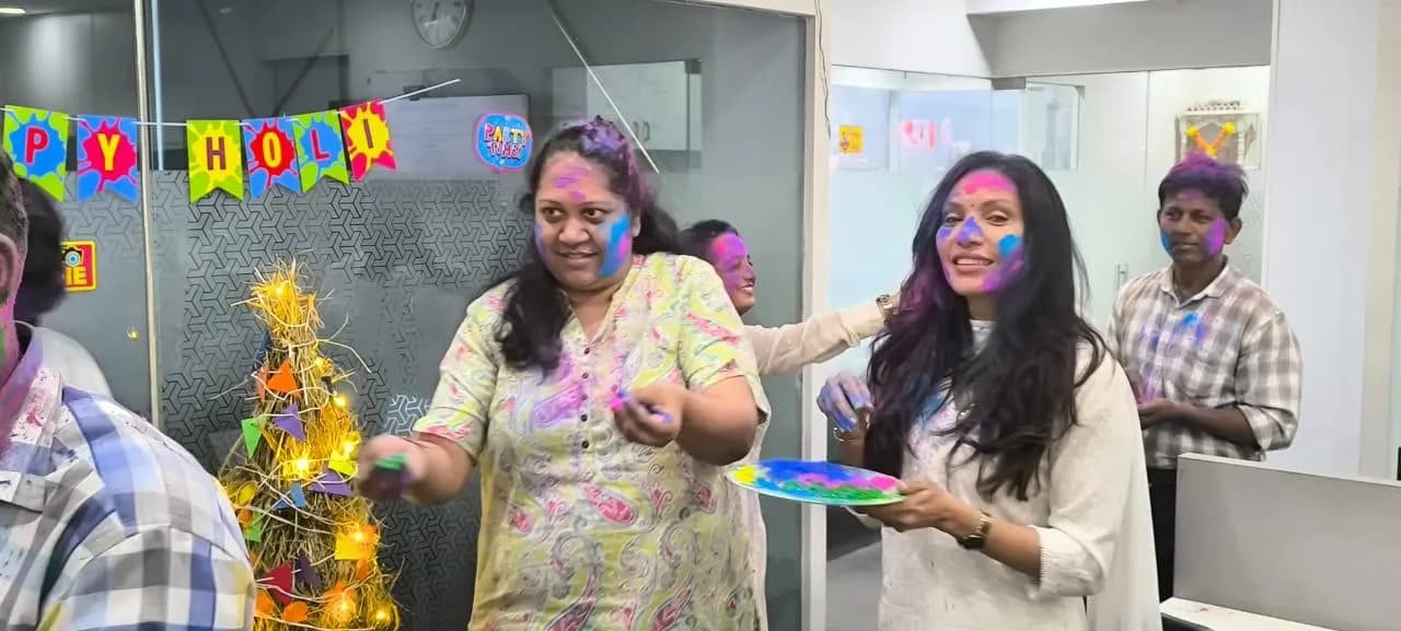 KIPL colleagues covered in coloured powder at the office Holi