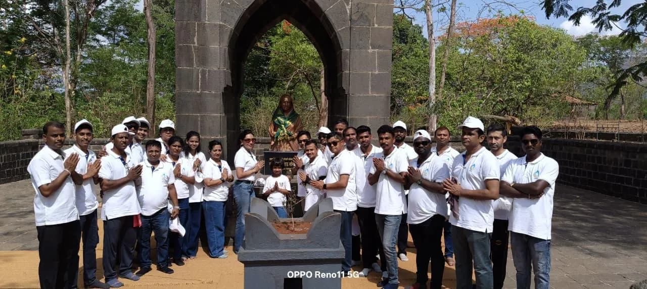 The KIPL team in matching white shirts and caps at a gateway of Raigad fort